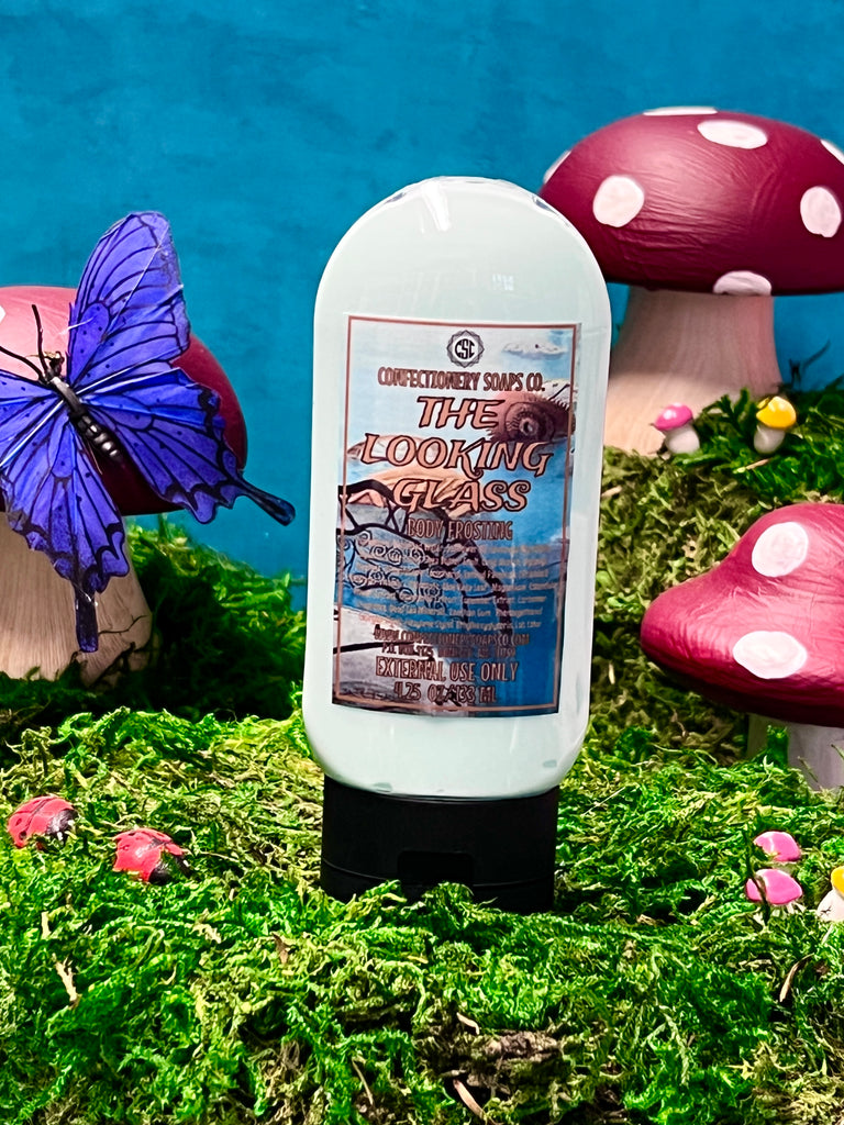 one body frosting (front view) sitting on top of grass, whimiscal mushrooms , butterflies and lady bugs surrounding product. 